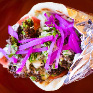 Veggie Falafel Gyro. (Hummus, Tomatoes, Cucumbers, Parsley, Tahini Sauce, & Pickled Turnips)