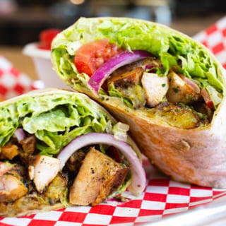 Caribbean Chicken Wrap. (Chicken, Plantains, Jalapeno Cilantro Hummus, Lettuce, Tomato, Onion, Cilantro Tahini Sauce)